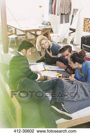 Stock Image - College students studying on bed. Fotosearch