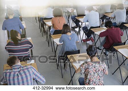 College students taking test at desks in classroom View Large Photo Image Picture - College students taking test at desks in classroom. Fotosearch