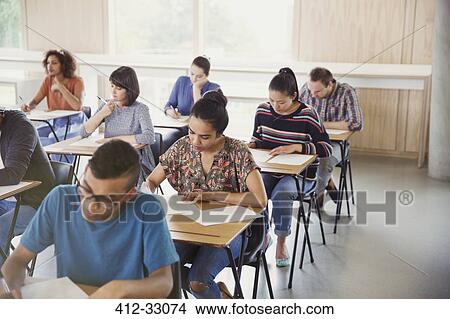 College students taking test at desks in classroom View Large Photo Image Picture - College students taking test at desks in classroom. Fotosearch