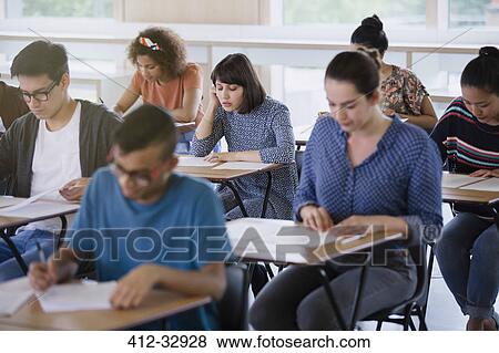 College students taking test at desks in classroom View Large Photo Image Stock Photo - College students taking test at desks in classroom. Fotosearch