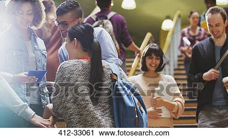 Stock Image - College students talking and descending stairway. Fotosearch