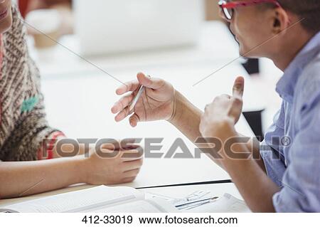 Stock Photo - College students talking and gesturing studying. Fotosearch