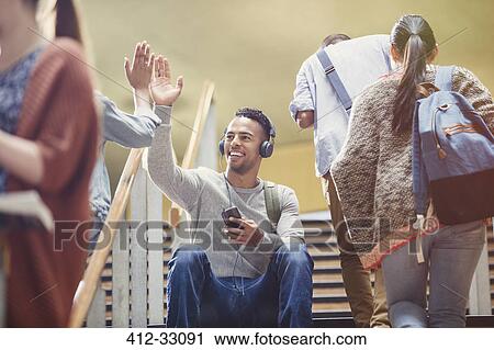 College students with headphones and mp3 player high-fiving in stairway View Large Photo Image Stock Image - College students with headphones and mp3 player high-fiving in stairway. Fotosearch
