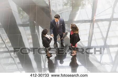 Corporate business people talking in modern office lobby View Large Photo Image Stock Image - Corporate business people talking in modern office lobby. Fotosearch