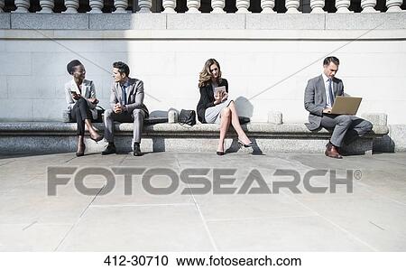 Corporate business people working on sunny bench outdoors View Large Photo Image Stock Image - Corporate business people working on sunny bench outdoors. Fotosearch
