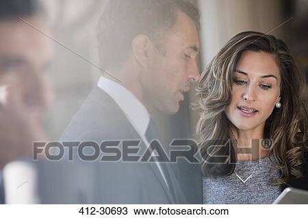 Stock Image - Corporate businessman and businesswoman using digital tablet. Fotosearch