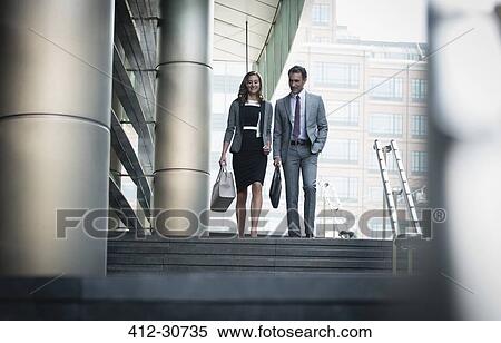 Corporate businessman and businesswoman descending stairs outdoors View Large Photo Image Stock Photography - Corporate businessman and businesswoman descending stairs outdoors. Fotosearch