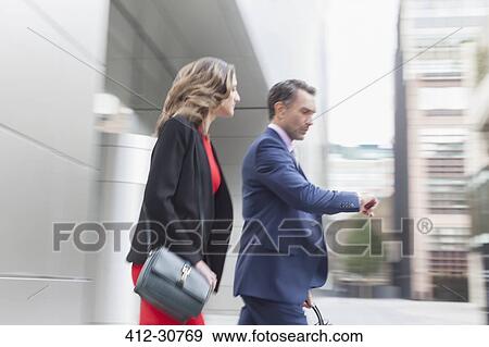Stock Photo - Corporate businessman checking wristwatch outdoors. Fotosearch
