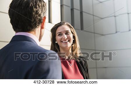 Stock Photo - Corporate businesswoman smiling and talking to businessman. Fotosearch