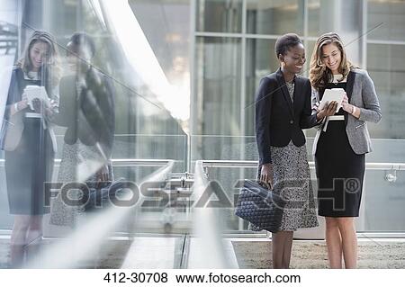 Stock Photo - Corporate businesswomen using digital tablet. Fotosearch