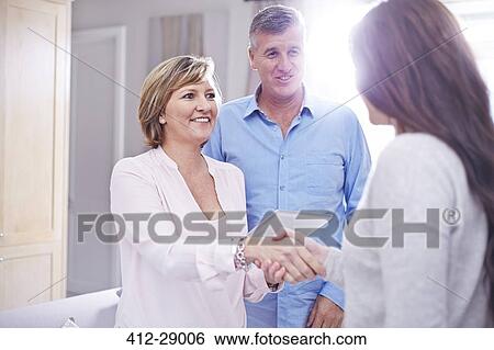 Couple shaking hands with interior designer View Large Photo Image Stock Photograph - Couple shaking hands with interior designer. Fotosearch