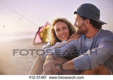 Couple sitting and talking on beach View Large Photo Image Stock Image - Couple sitting and talking on beach. Fotosearch