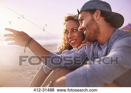 Stock Photo - Couple talking on sunny beach. Fotosearch