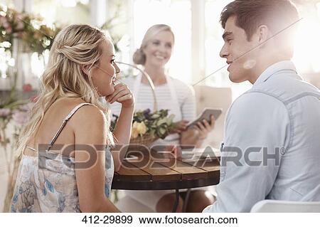 Stock Photo - Couple talking with florist in flower shop. Fotosearch