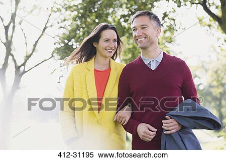 Stock Photography - Couple walking arm in arm in park. Fotosearch