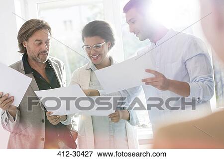 Creative business people reviewing proofs in office View Large Photo Image Stock Photo - Creative business people reviewing proofs in office. Fotosearch