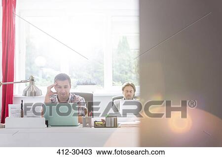 Stock Image - Creative businessman working at laptop in office. Fotosearch