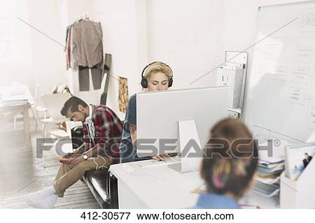 Creative young adult designers working in office View Large Photo Image Stock Photo - Creative young adult designers working in office. Fotosearch