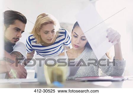 Creative young business people reviewing paperwork View Large Photo Image Stock Photography - Creative young business people reviewing paperwork. Fotosearch