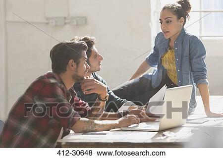 Stock Photo - Creative young business people working in office. Fotosearch