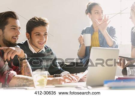 Creative young business people working at laptop View Large Photo Image Stock Photography - Creative young business people working at laptop. Fotosearch