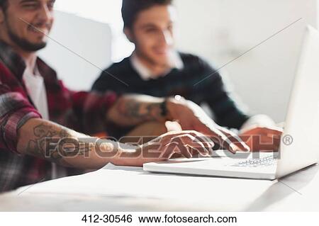 Creative young businessmen working at laptop View Large Photo Image Stock Photograph - Creative young businessmen working at laptop. Fotosearch