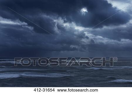 Picture - Dark clouds in overcast sky over stormy ocean, Devon, United Kingdom. Fotosearch