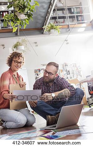 Design professionals discussing proofs at laptop on office floor View Large Photo Image Stock Photo - Design professionals discussing proofs at laptop on office floor. Fotosearch