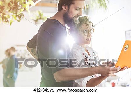 Design professionals with laptop meeting in office View Large Photo Image Stock Photography - Design professionals with laptop meeting in office. Fotosearch