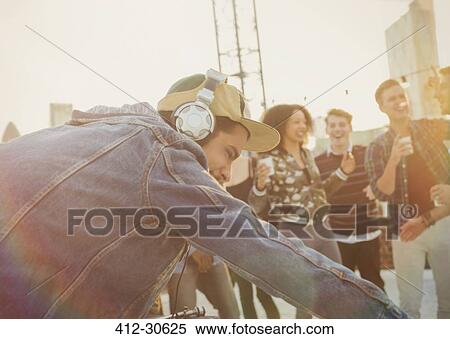 Stock Photography - DJ with headphones at rooftop party. Fotosearch