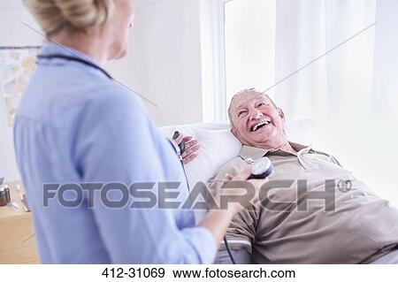Stock Photo - Doctor checking senior mans blood pressure. Fotosearch