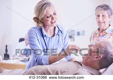 Doctor checking senior mans temperature View Large Photo Image Stock Photograph - Doctor checking senior mans temperature. Fotosearch