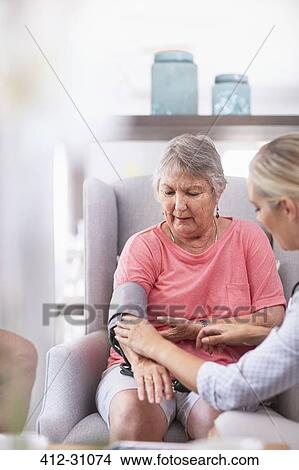 Picture - Doctor checking senior womans blood pressure. Fotosearch