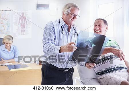 Doctor showing senior man x-ray View Large Photo Image Stock Image - Doctor showing senior man x-ray. Fotosearch