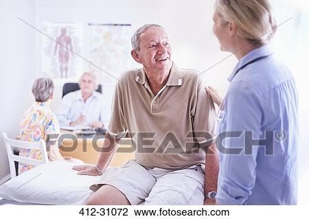 Doctor talking to senior man in examination room View Large Photo Image Stock Image - Doctor talking to senior man in examination room. Fotosearch