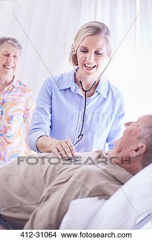 Picture - Doctor using stethoscope on senior man. Fotosearch