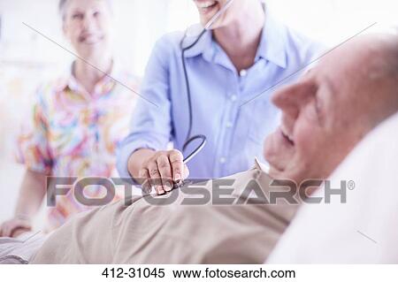 Doctor using stethoscope on senior man View Large Photo Image Stock Photography - Doctor using stethoscope on senior man. Fotosearch