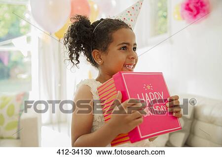 Eager girl holding birthday gift View Large Photo Image Stock Image - Eager girl holding birthday gift. Fotosearch