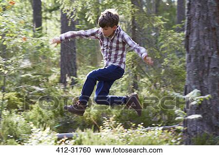 Energetic boy jumping in woods View Large Photo Image Stock Image - Energetic boy jumping in woods. Fotosearch