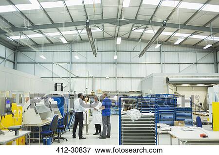 Stock Photo - Engineer and managers talking in steel factory. Fotosearch