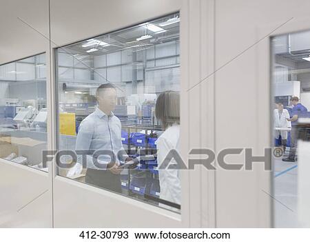 Stock Image - Engineer and supervisor talking in steel factory. Fotosearch