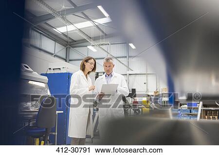 Engineers discussing paperwork in steel factory View Large Photo Image Stock Image - Engineers discussing paperwork in steel factory. Fotosearch