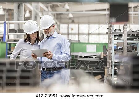 Engineers using digital tablet in steel factory View Large Photo Image Stock Image - Engineers using digital tablet in steel factory. Fotosearch