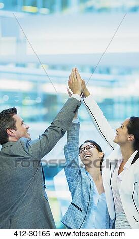 Enthusiastic business people with arms raised in office View Large Photo Image Stock Photography - Enthusiastic business people with arms raised in office. Fotosearch