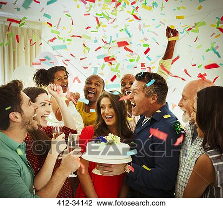 Enthusiastic family with birthday cake throwing confetti View Large Photo Image Stock Image - Enthusiastic family with birthday cake throwing confetti. Fotosearch
