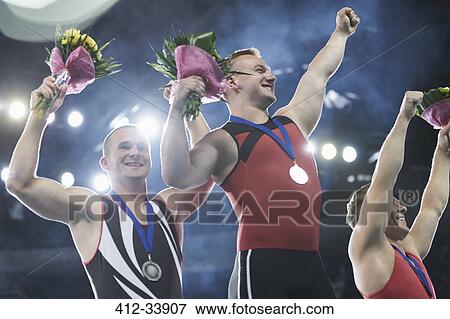 Enthusiastic gymnasts cheering celebrating victory on winners podium View Large Photo Image Stock Photo - Enthusiastic gymnasts cheering celebrating victory on winners podium. Fotosearch