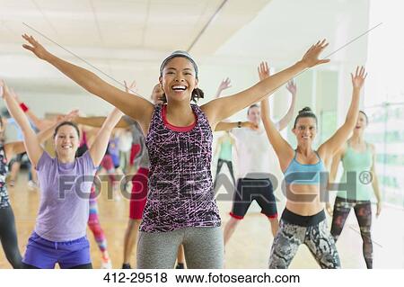 Stock Photo - Enthusiastic woman with arms outstretched in aerobics class. Fotosearch