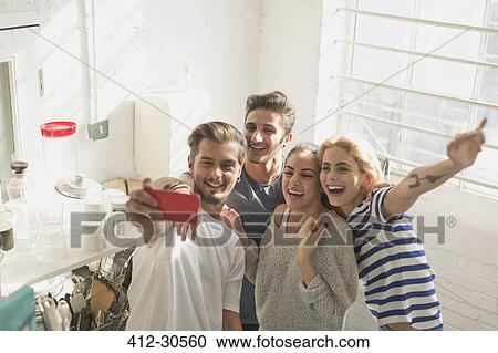 Enthusiastic young adult roommates taking selfie in kitchen View Large Photo Image Stock Image - Enthusiastic young adult roommates taking selfie in kitchen. Fotosearch