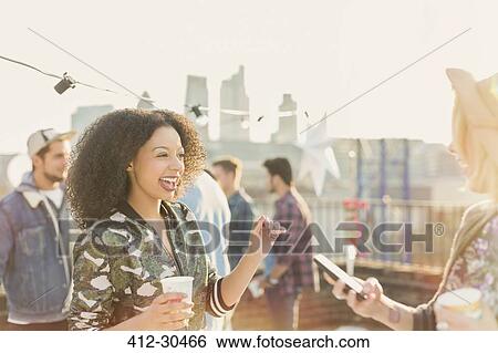 Enthusiastic young women enjoying rooftop party View Large Photo Image Stock Photograph - Enthusiastic young women enjoying rooftop party. Fotosearch