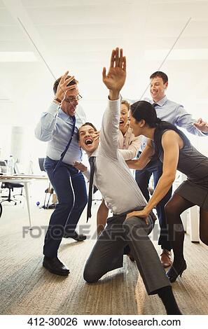 Exuberant business people celebrating and dancing in office View Large Photo Image Stock Photograph - Exuberant business people celebrating and dancing in office. Fotosearch
